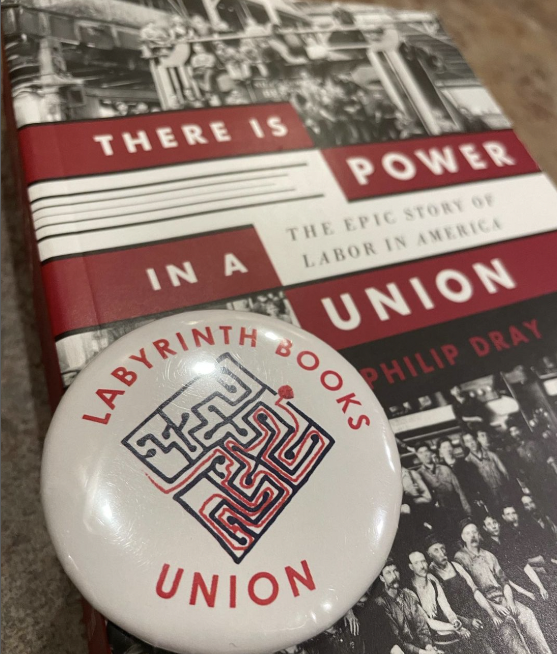 union pin reading labyrinth books union lays over a labor book