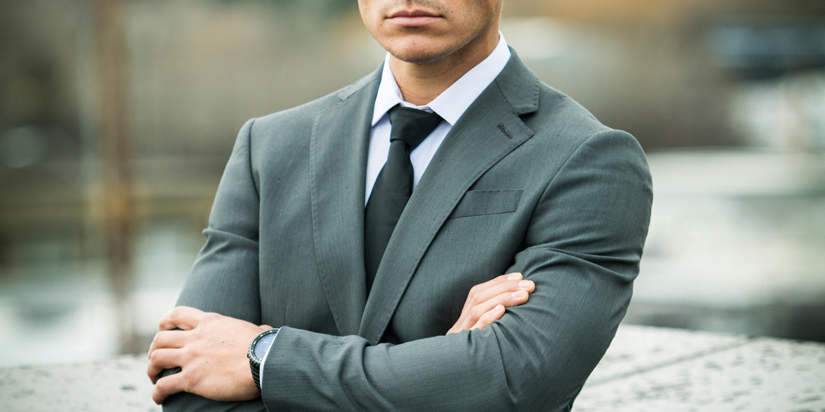 man in suit with arms folded