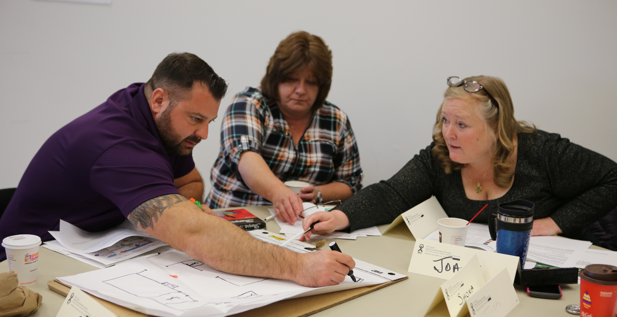 three workers collaborate on a plan