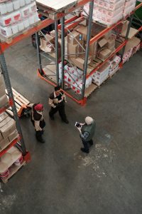 Workers stand in a warehouse