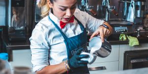 barista pouring milk into cup